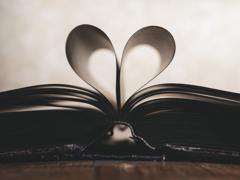 Open book with pages forming a heart.